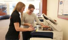 Two female students making copies 