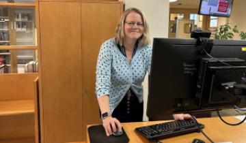 Alison Holah standing at the reference desk at the law library 