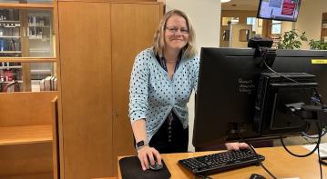Alison Holah standing at the reference desk at the law library 
