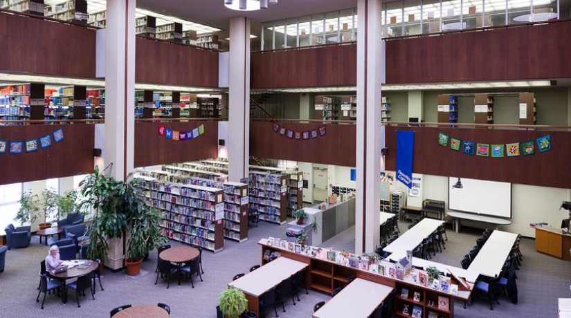 Inside the Education Library showing shelves on books and tables with chairs