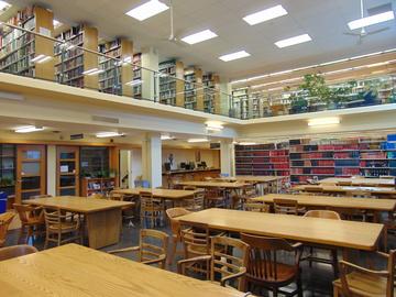 Photo at Lederman Library of many long wooden tables and chairs