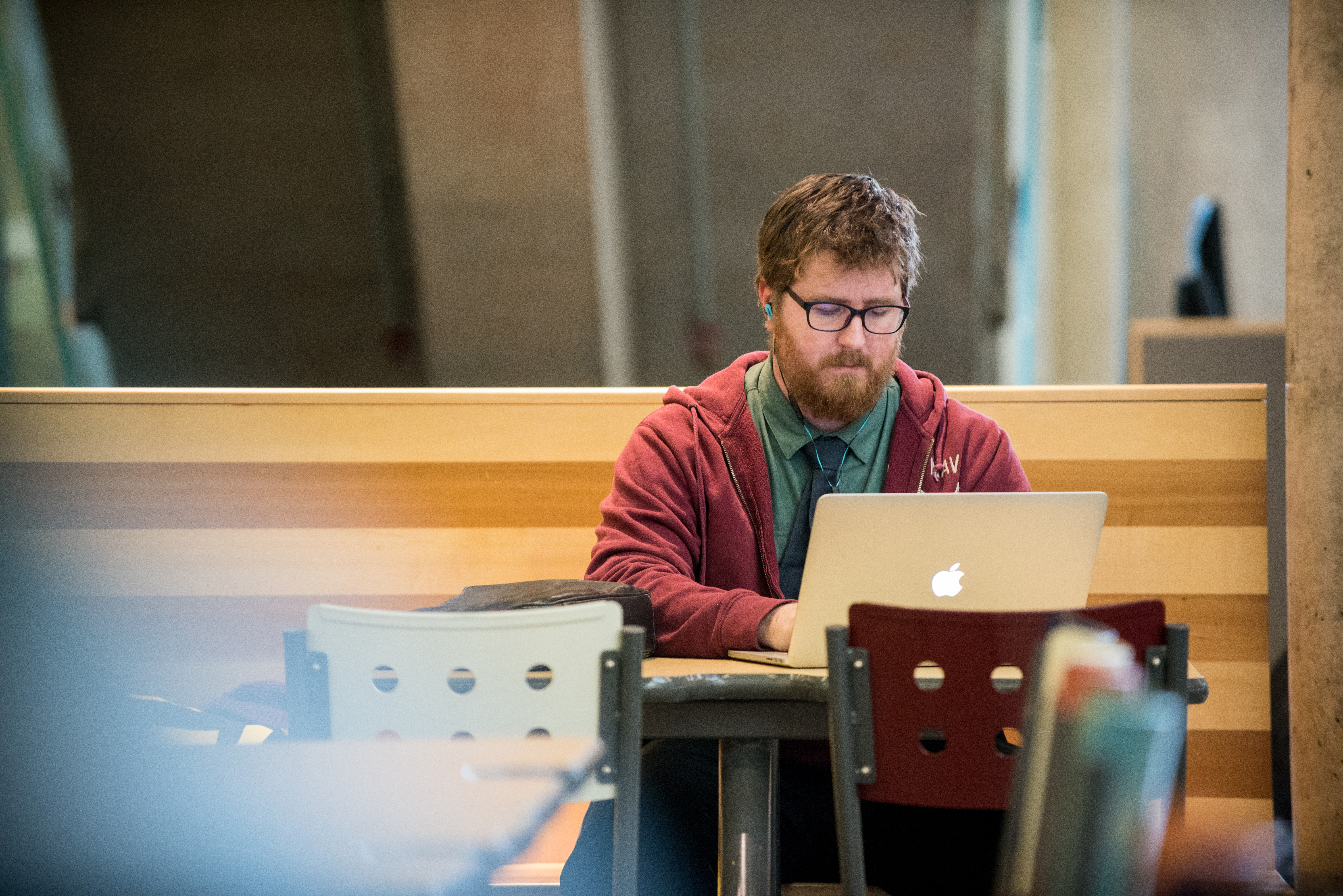 Person sitting at a table and working on a laptop.