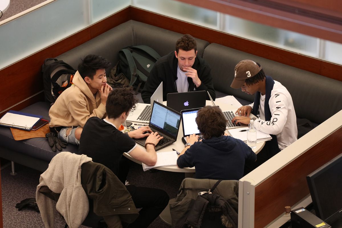 Group of five students studying in the library