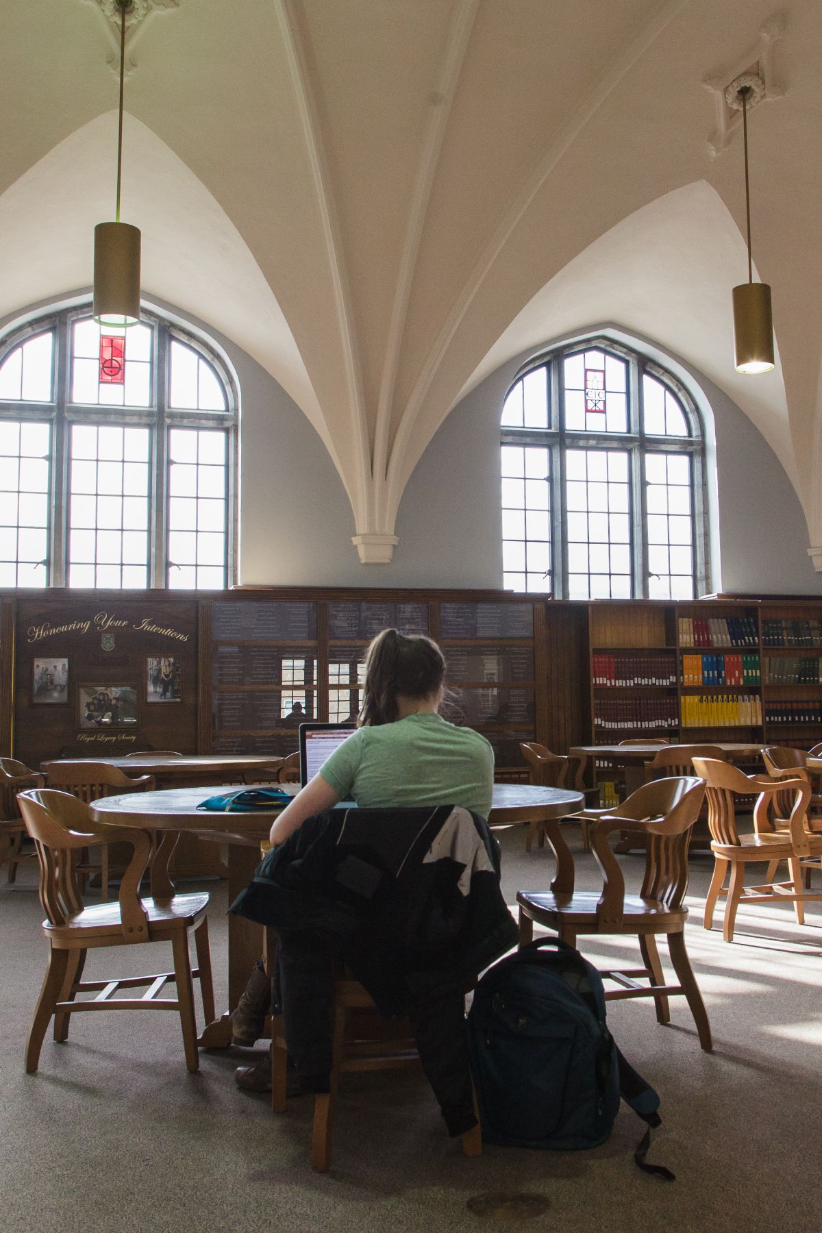 student studying at round table with big windows in the background.