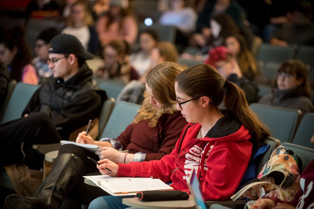 Students sitting in a lecture hall taking notes