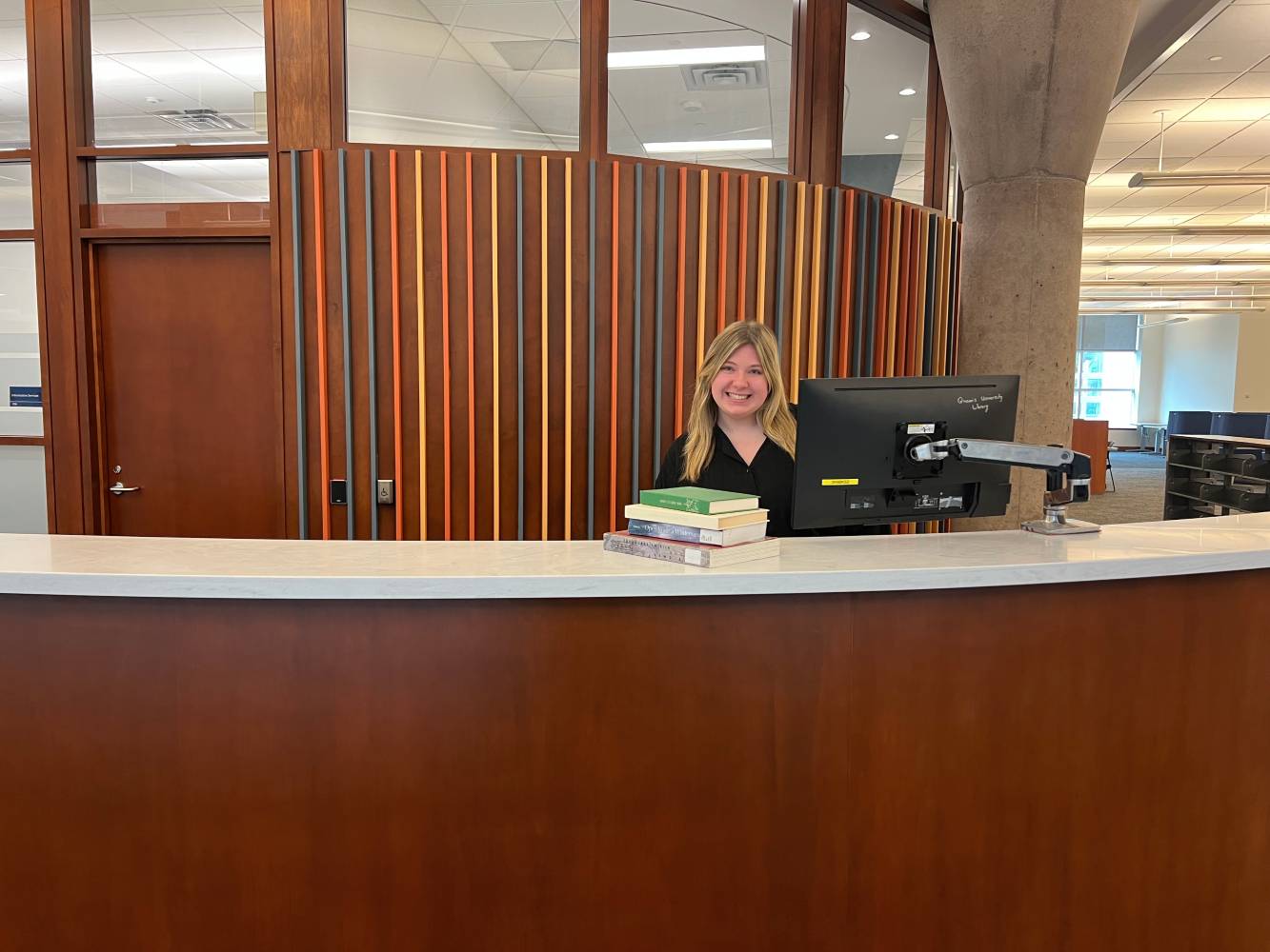 A smiling employee at the information services desk