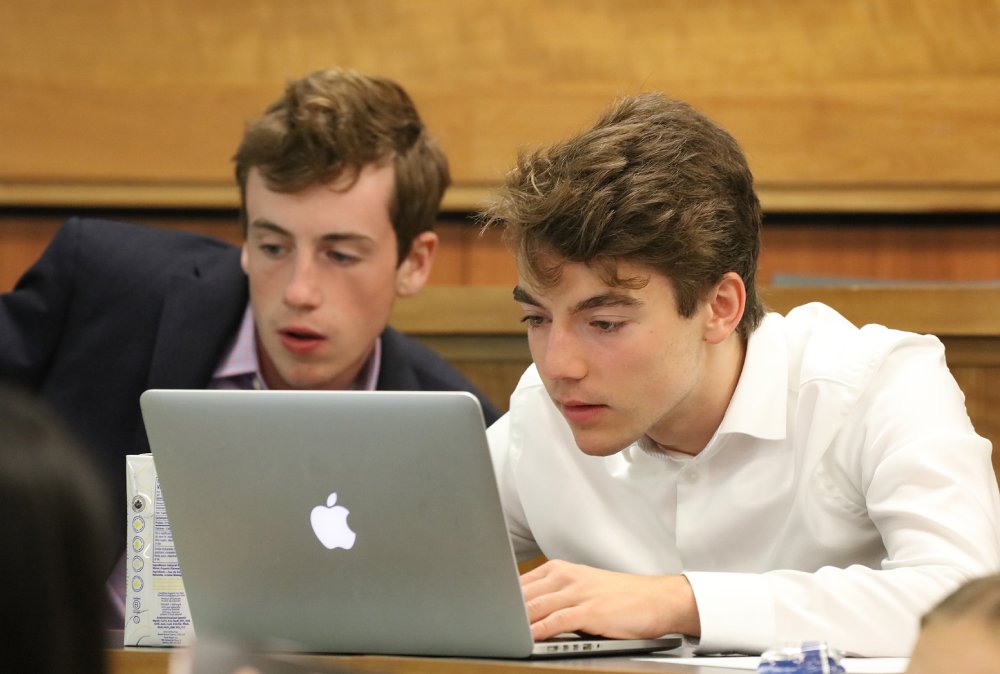 Two male students looking at a laptop 