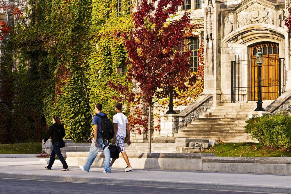 People walking by Douglas Library in the fall
