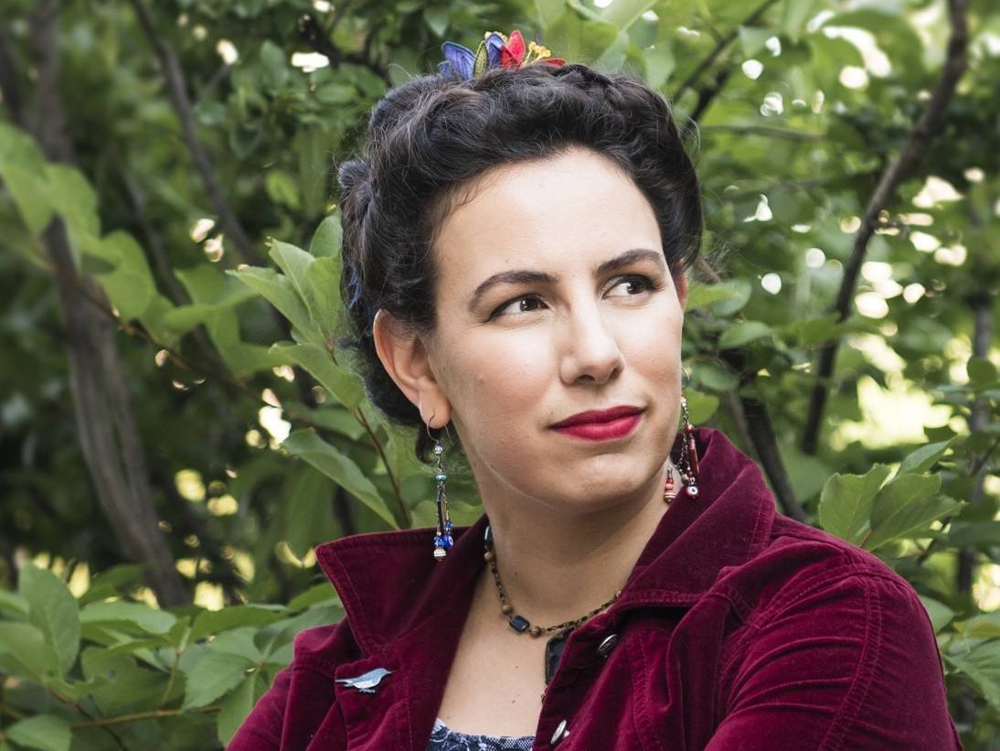 Amal in front of a leafy backdrop