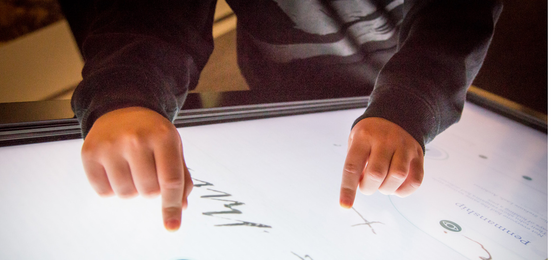 Child's hand touching an interactive exhibit at He Tohu in Wellington