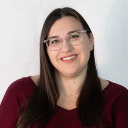 Photo of woman with brown hair and glasses.