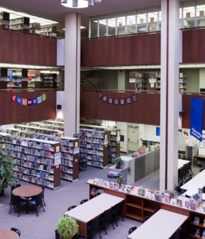 Inside the Education Library showing shelves on books and tables with chairs