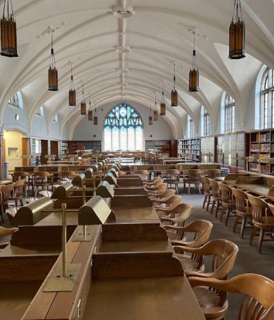 Interior view of the 1923 reading room, featuring rows of student seating, arched ceilings and stain glass window