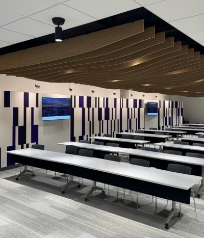 Interior view of the podium, tables and screen in the staff and student learning centre