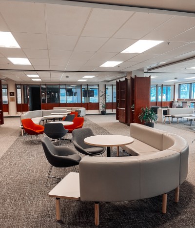 Study space in Bracken Library with grey couches and red chairs