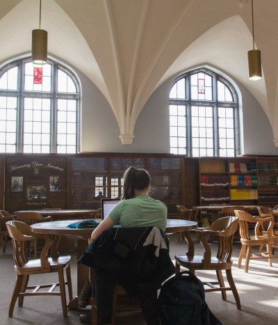 student studying at round table with big windows in the background.