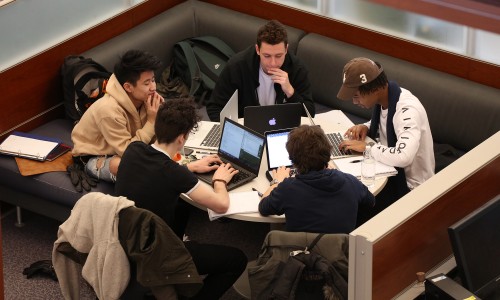 Group of five students studying in the library