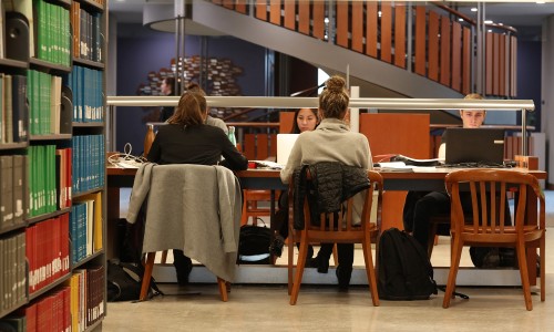 Several students studying in the library.