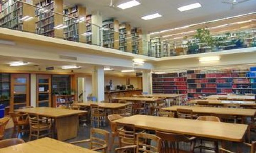 Photo at Lederman Library of many long wooden tables and chairs