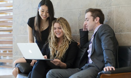 three students working together on a laptop