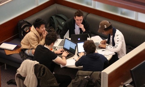 Group of five students studying in the library