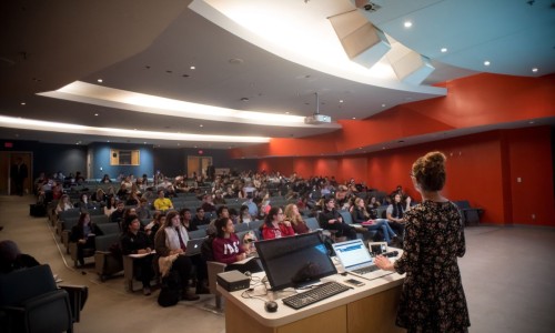 Instructor at podium teaching class of students