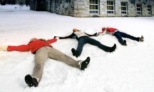 students lying in the snow