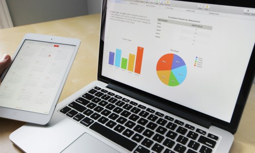 A laptop displaying charts and graphs