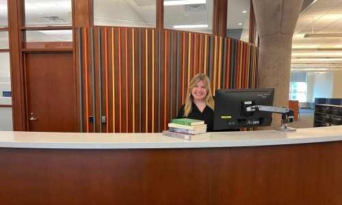 A smiling employee at the information services desk