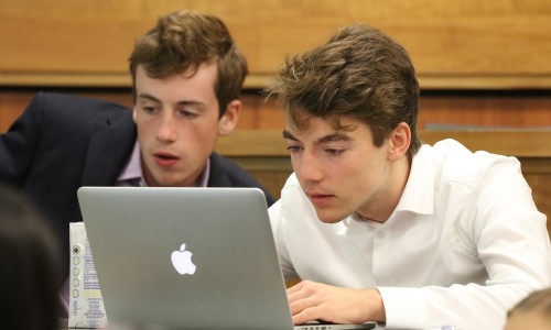 Two male students looking at a laptop