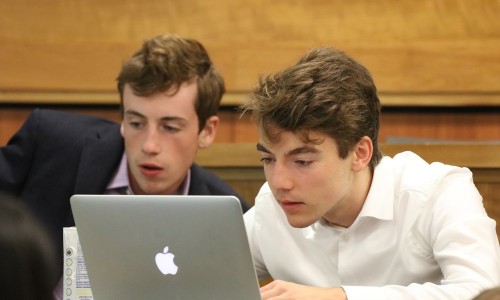 Two male students looking at a laptop