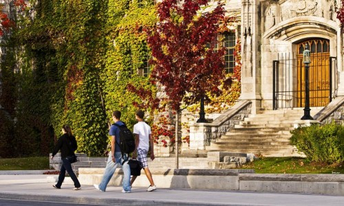 People walking by Douglas Library in the fall