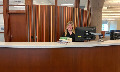 smiling woman at the Stauffer information services desk