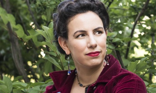 Amal in front of a leafy backdrop