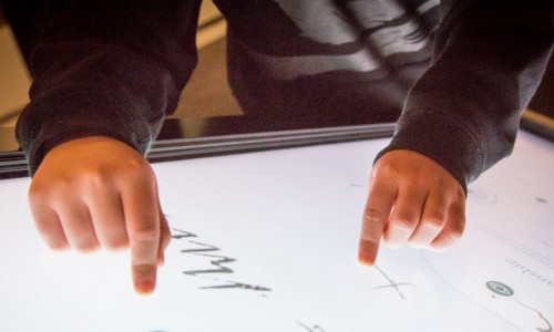 Child's hand touching an interactive exhibit at He Tohu in Wellington